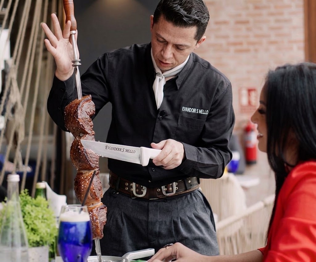 Evandoir S Mello realizando serviço de churrasco à mesa